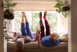 Elderly couple on sofa with legs up