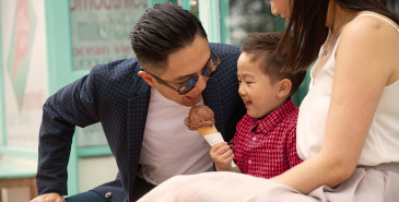 Parents and young child outside eating icecream