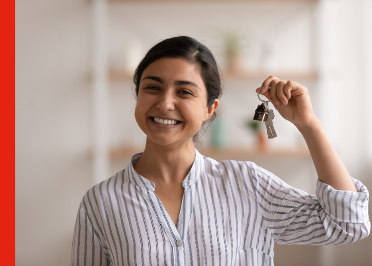 A first home buyer smiles and holds up her house keys