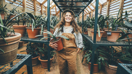 Woman Farmer Holds Flowers In A Greenhouse