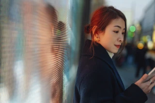 Woman Using Phone Against Led Lights On City Street