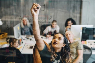 Woman drawing on a clear screen in an office