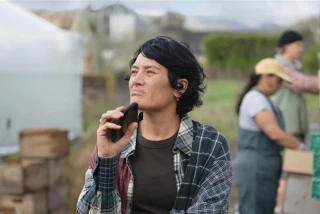 Woman holds phone while outside packing shed