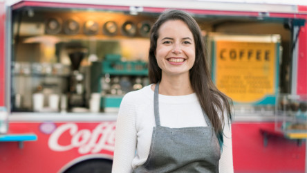 Woman standing in front of a coffee cart.