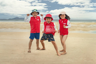 Kids on a beach wearing Rescue Rashies