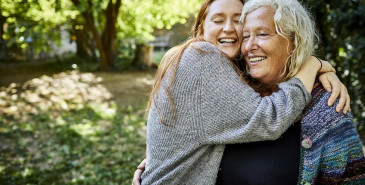 Elderly woman and a girl hugging.