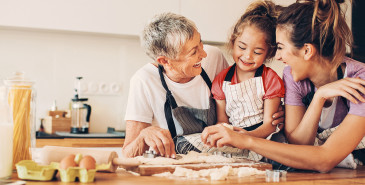 Three generations preparing cookies together in kitchen