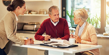 Couple discussing papers with professional.