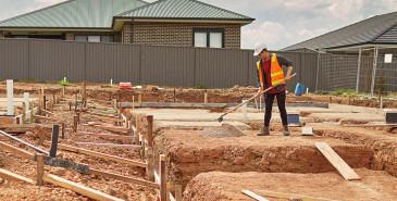 Builder clearing foundations for property site.