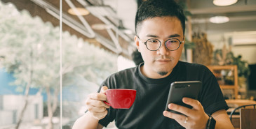 Freelancer checking phone during lunch in cafe