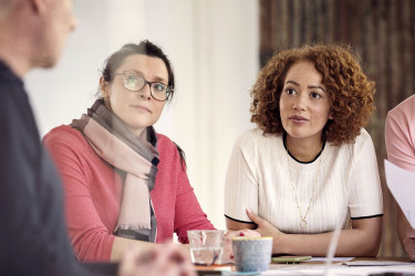Colleagues sitting at table brainstorming in office
