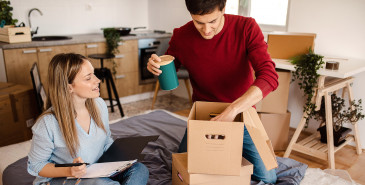 Couple unpacking belongings into new home