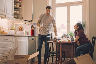 Couple unpacking kitchen boxes into new home
