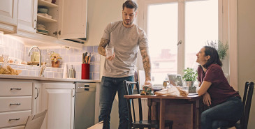 Couple unpacking kitchen boxes into new home