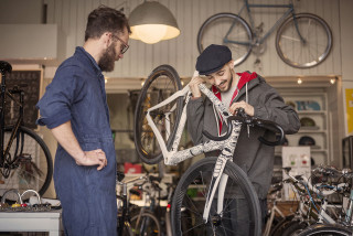 Mechanic and customer in bicycle repair shop