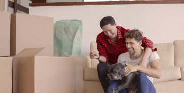 Young couple moving in together with dog and boxes