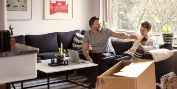 Parent and teenager laughing on sofa