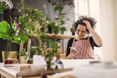 Happy florist working on phone
