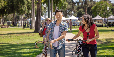 Friends walking outside with bikes in park