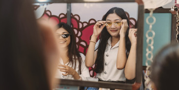 Friends shopping, trying on glasses
