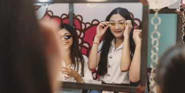 Friends shopping, trying on glasses