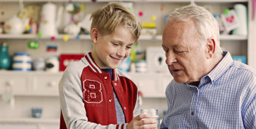 Grandparents and child saving coins in jar