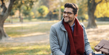 Young professional sitting on bench in park