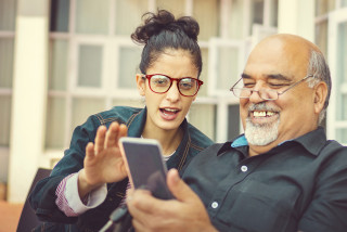Parent and adult child looking at smart phone screen