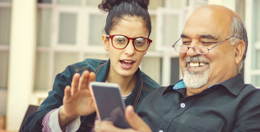 Parent and adult child looking at smart phone screen