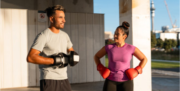 Woman and man both in gym gear and wearing boxing gloves