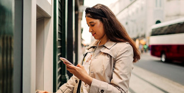 Person using atm machine and mobile 