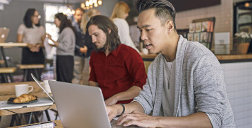 Person in cafe in front of laptop doing research