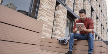 Person sitting outside reading information on tablet