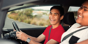 Two friends laughing in the car while driving