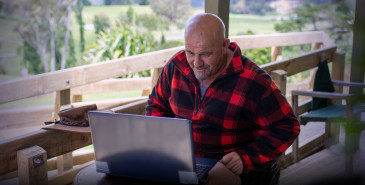 Man sitting at table looking at laptop