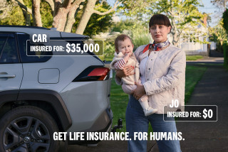 Woman standing next to car holding baby