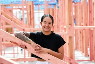 Woman stands inside her new home as its under construction