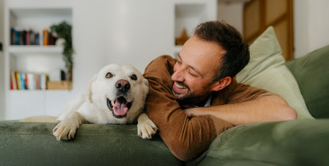 Man and his dog looking over the back of the couch