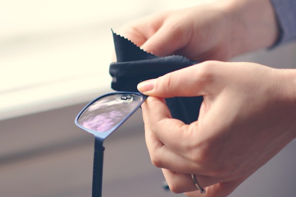 Photo of a person cleaning their glasses