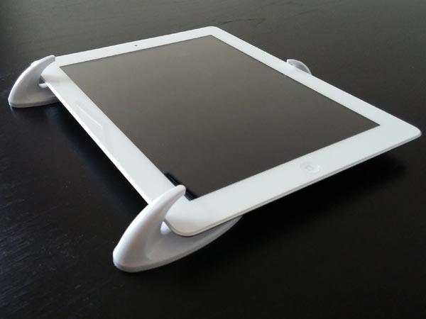 Photo of an iPad held by adhesive hooks.