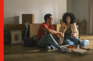 Couple sit on the floor eating pizza in their new home Couple sit on the floor eating pizza in their new home