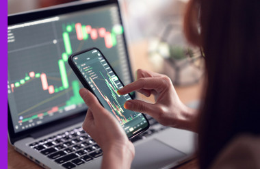 Photo of women checking the currency market on her app.