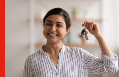 A first home buyer smiles and holds up her house keys
