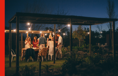 People around a picnic table outdoors at night People around a picnic table outdoors at night