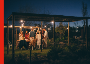 People around a picnic table outdoors at night