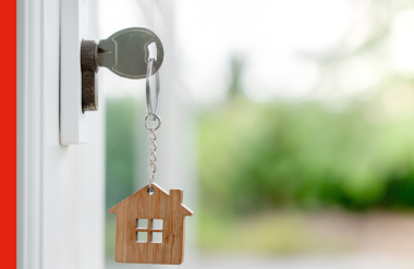 Key to house A key in a lock with a miniature house keyring