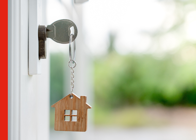 Key to house A key in a lock with a miniature house keyring