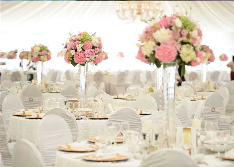 Table settings at a wedding with large bouquets of flowers as centrepieces