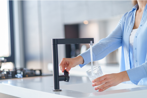 Photo of woman getting tap water